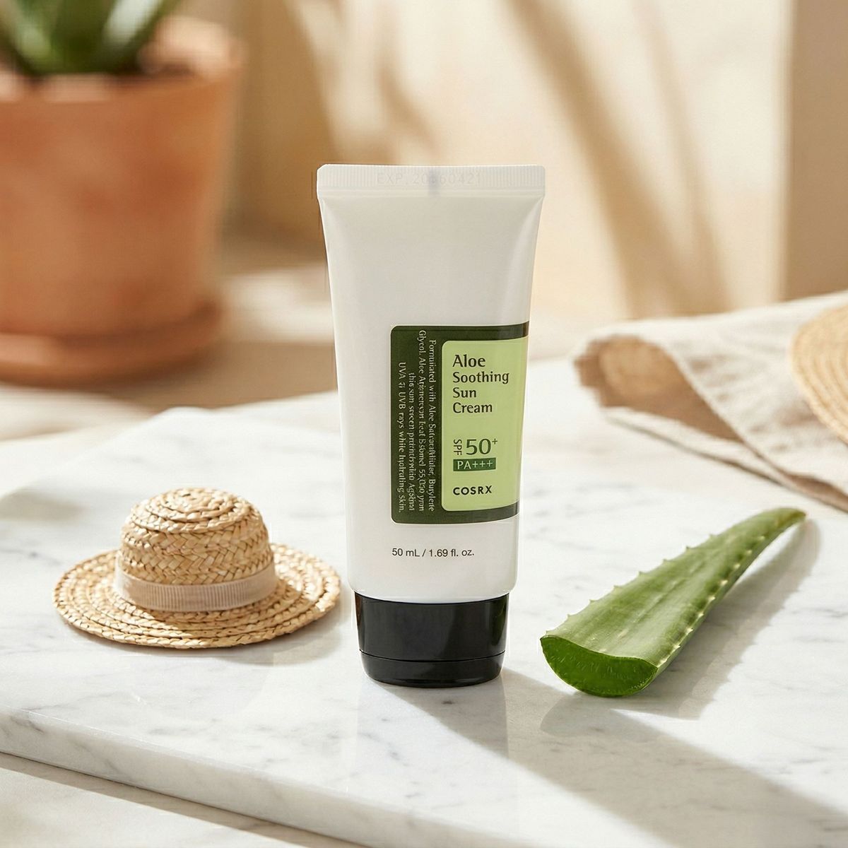 COSRX Aloe Soothing Sun Cream on marble surface with aloe leaf