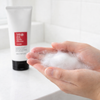Hands lathering COSRX Salicylic Acid Cleanser into rich foam
