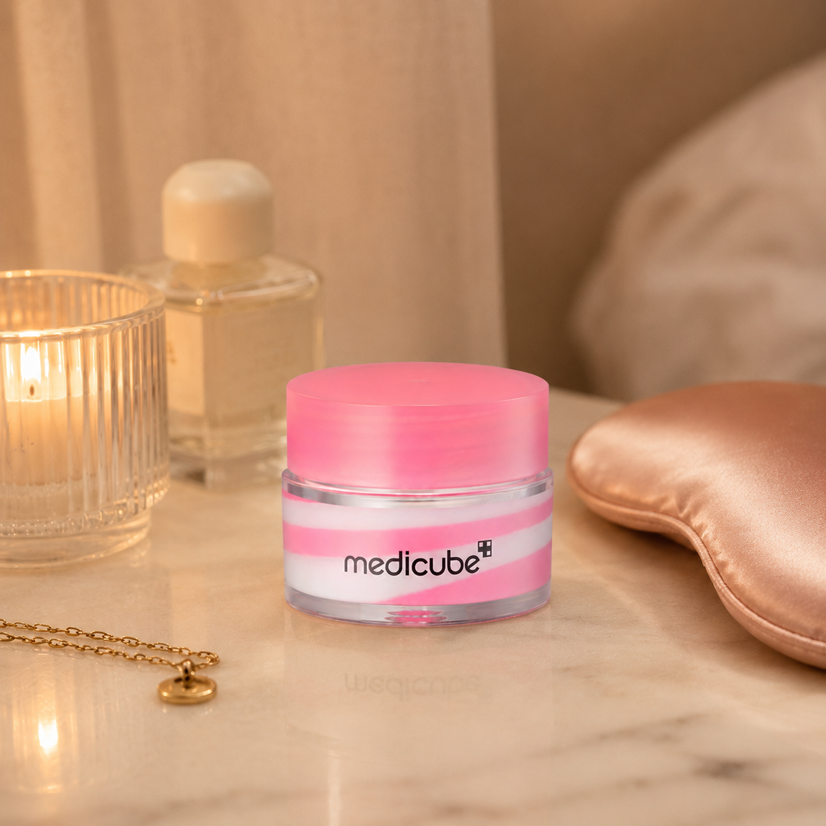 Medicube PDRN Lip Sleeping Mask on pink surface with salmon-colored silk