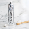 Marvis Whitening Mint Toothpaste squeezed onto a wooden toothbrush