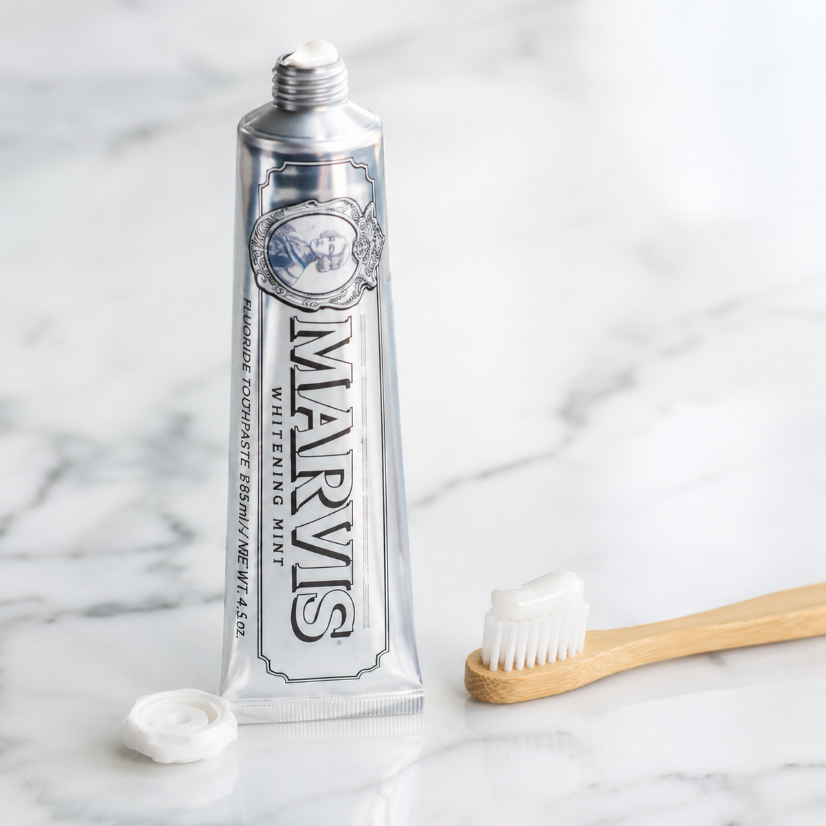 Marvis Whitening Mint Toothpaste squeezed onto a wooden toothbrush